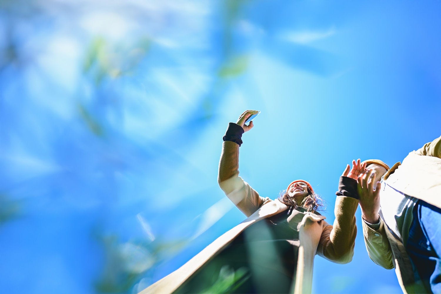 People looking at a phone with blue sky in the background