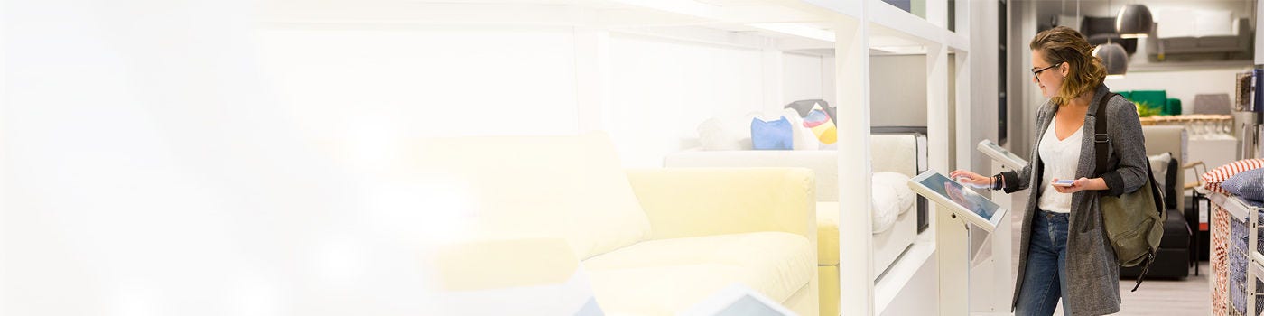 Woman with phone configuring furniture at the self-service device in the store banner