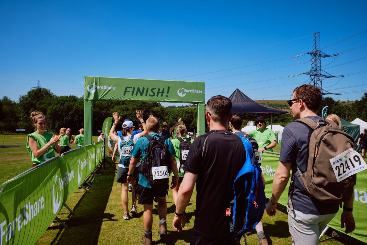 Colleagues of KPMG UK walking at a charity fundraising event in a field
