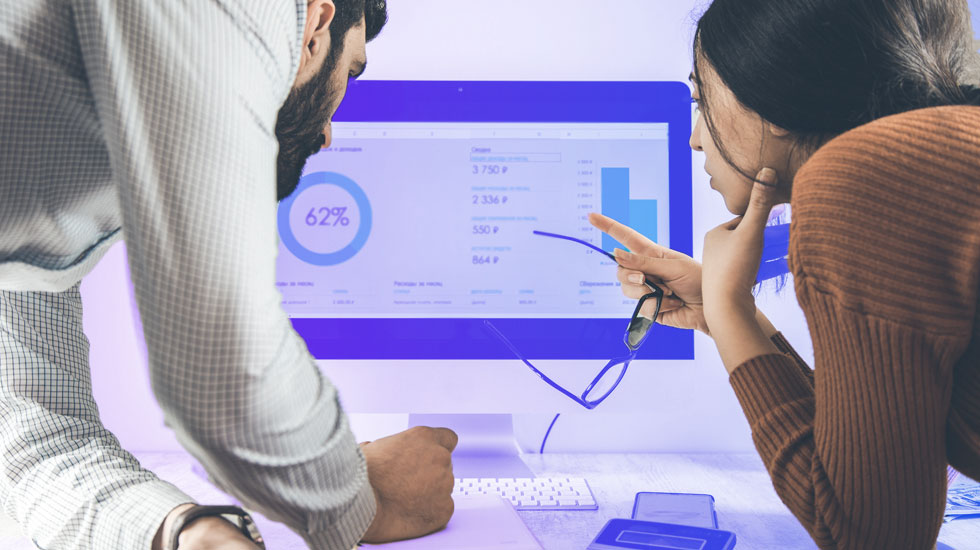 two colleagues reviewing statistical data on computer screen